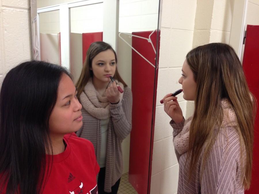Kaitlin watches Michelle apply lipstick 