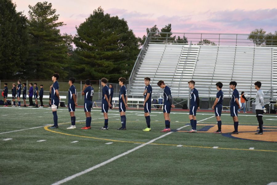 The BG boys varsity soccer players stand for the nation anthem before their senior night game.