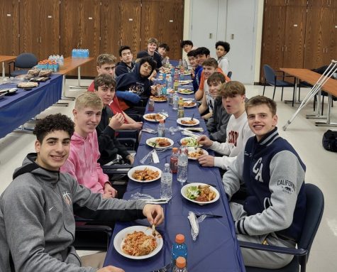 The varsity boys basketball team enjoys one of their many team dinners in the community room at BG.